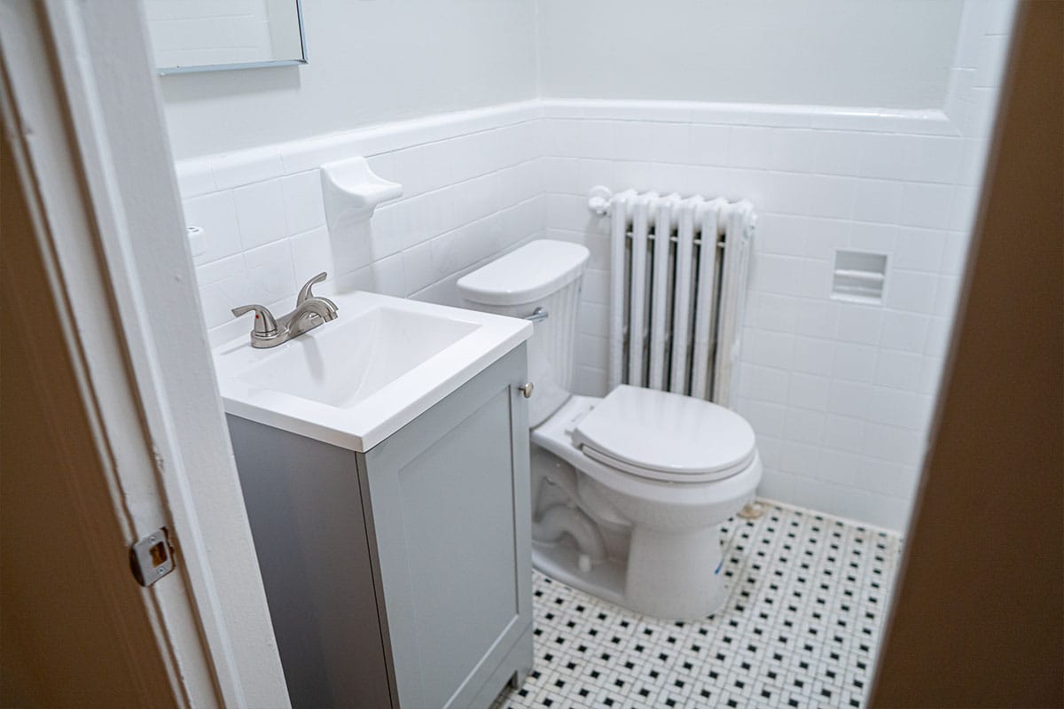 Close look at a new sink, custom cabinet and toilet installed inside a bathroom located in Washington DC