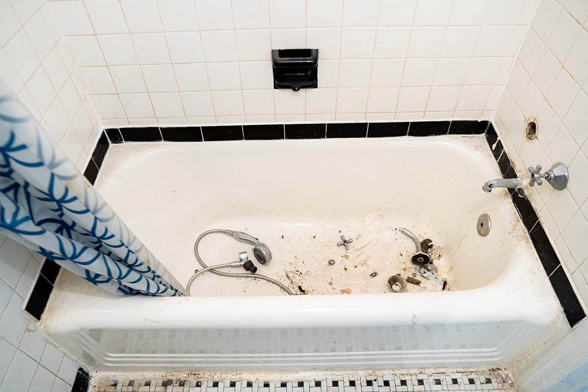 Wide view of an outdated bathtub inside a DC apartment bathroom