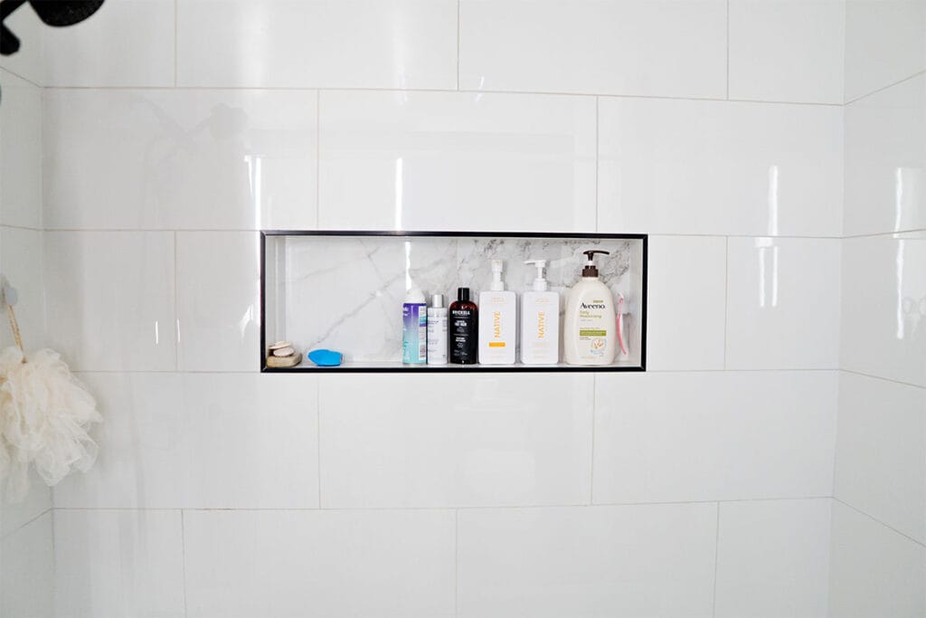 Ceramic shower niche installed in a tub and shower inside a Virginia hallway bathroom