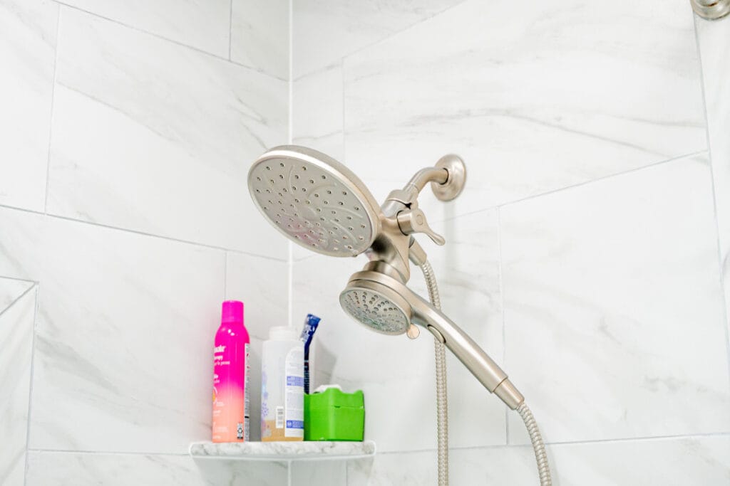 Closeup on new shower head installed in a tub and shower inside a hallway bathroom in DC