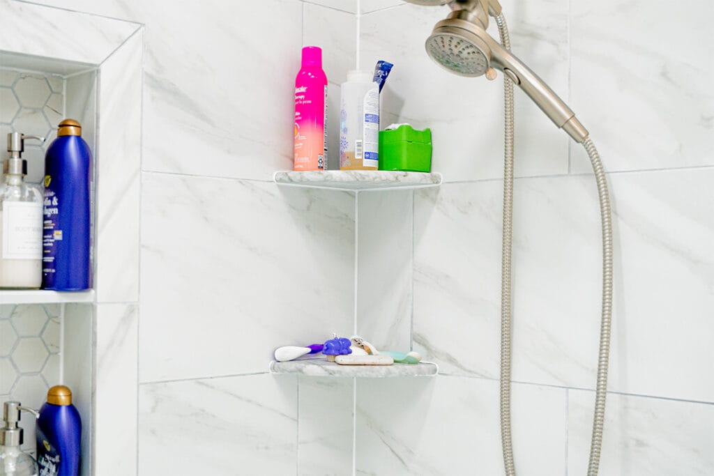 Closeup on shelves installed inside a tub and shower built inside a DC hallway bathroom