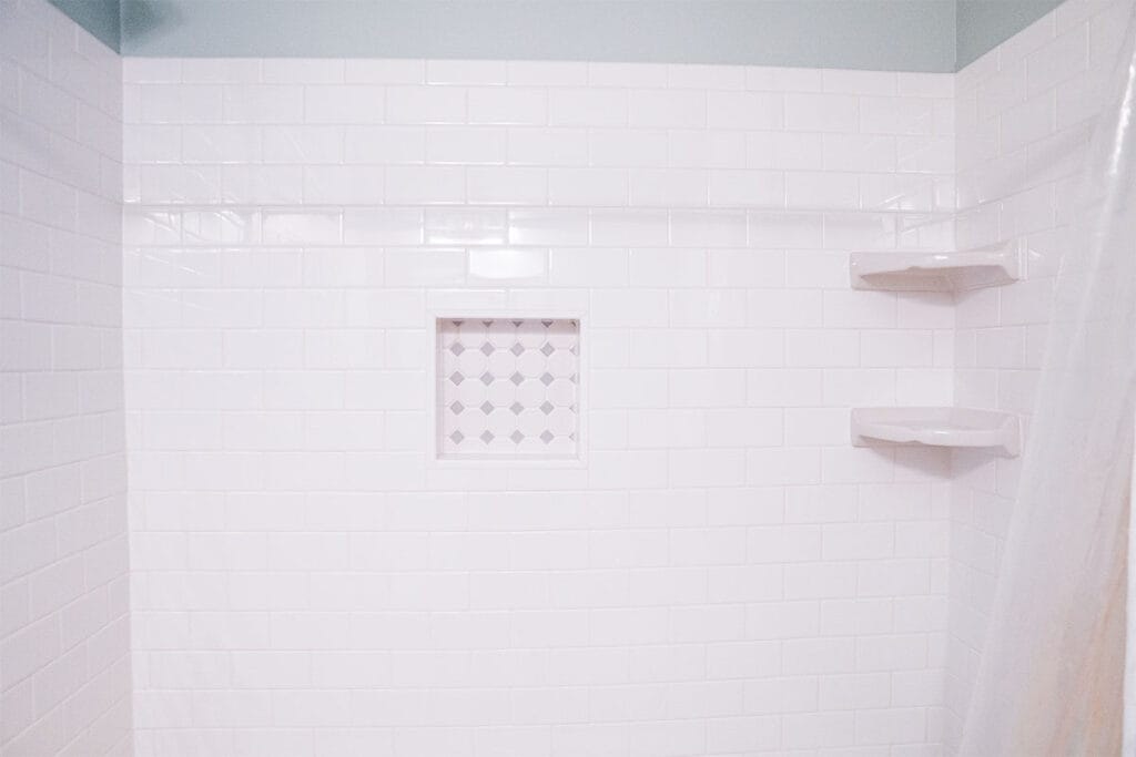 Wide view of white ceramic shower walls installed in a tub and shower inside a Takoma DC hallway bathroom